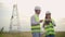 Engineering working on High-voltage tower, Check the information on the tablet computer two employees man and woman.