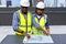 Engineers with draft plan of building on constructing site. Engineer working on building site. Engineer working with drawing Syste