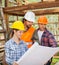 Engineers Examining Blueprint In Wooden Cabin