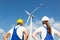 Engineers or installers posing in front of wind energy turbine