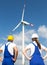 Engineers or installers posing in front of wind energy turbine