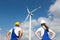 Engineers or installers posing in front of wind energy turbine