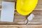 Engineers maintenance office construction, hard hat with notepad wireless headphones on vintage wood board