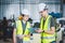 Engineers mechanic team holding check list on clipboard and pen in steel factory workshop. Industry robot programming software for