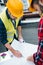 engineers in safety vests and hardhats with digital tablet drawing