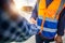 Engineers shaking hands at construction site, Construction worker in protective uniform shaking hands with businessman at