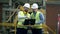 Engineers in uniform work with a laptop in a facility.