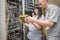 Engineers use a cable analyzer to measure the level of an optical signal in a data center. A man and a woman work with an