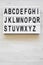 English alphabet on modern board over white wooden surface, top view. Letters from A to Z. Back to school concept. From above,