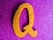 An English alphabet Q pink background shiney