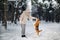 English Beagle with a girl playing in the winter forest.The owner plays with the dog jumping up