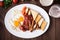 English breakfast (fried eggs, beans, roasted bacon, sausages and vegetables) on dark wood background