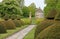 An English country garden with rounded topiary bushes with a conical top