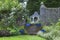 English garden with blue pots, roses, old wooden arbour