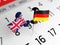 English and German flags are pinned on a white-colored calendar page.