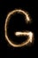 English Letter G from sparklers alphabet on black background.