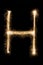 English Letter H from sparklers alphabet on black background.