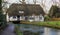 English mill cottage with Thatched roof built over a river