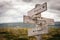 English, spanish and french wooden signpost outdoors.