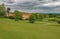 English stately home set in acres of grassland. The sky is very black and cloudy