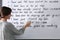 English teacher underlining word on whiteboard at lesson