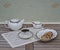 English teacup with saucer, teapot, cream jug and a cake bowl with cookies, fine bone china porcelain, on a sheet of music