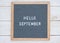 English text Hello September on a letter Board in white letters on a gray background