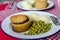 English traditional pie with mashed potatoes and garden green peas with gravy on the red table