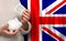 English woman with money bank on the background of UK flag. Dotations, pension fund, poverty, wealth, retirement concept