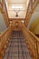 Engllish country house, wooden stairs and carpet strip. deer head