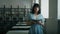 Engrossed woman reading book standing in a library. Informative portrait with depth of field. Continuous learning and