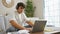 Engrossed young hispanic male student chilling at home, sitting on comfy sofa, focused on studying online via laptop, perfectly