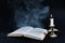 Enigmatic Aura: Smoke, Book, and Candle on Dark Background