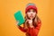 Enigmatic Young girl in sweater and hat holding book