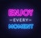 Enjoy every moment neon inspirational quote on a brick wall.