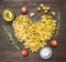 Enjoy homemade pasta with cherry tomatoes, rosemary, spices, salt and butter, pasta laid out the form of heart, top view