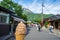 Enjoy melting chocolate ice cream soft serve cone on local street in spring with blurred people, mountain and blue sky background