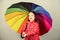 Enjoy rain concept. Fall season. Kid girl happy hold colorful rainbow umbrella. Rainy weather with proper garments