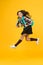 Enjoy school holidays. Happy girl run from school. Little child in midair yellow background. School holidays. Holidays