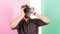 Enjoy virtual reality. Man unshaven guy with VR glasses, pink background. Hipster use modern technologies for