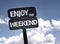 Enjoy the Weekend sign with clouds and sky background