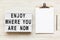 `Enjoy where you are now` words on lightbox, noticeboard, pencil