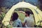 Enjoying camping couple lover sitting in tent together feeling happy and smiling