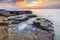 Enjoying the colorful sunset on a beach with rocks on the Adriatic Sea coast Istria Croatia