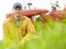 Enjoying the feeling of spring. Portrait of a farmer kneeling in a field with his tractor parked behind him.