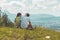 Enjoying the idyllic mountain landscape: Couple is sitting on idyllic meadow and enjoying the view over the far away city of