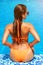 Enjoying luxury vacation. Back view of slim young sexy woman in swimming pool. Sexy tanned body. Woman in trendy bikini relax at