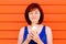 Enjoying the moment: young woman in blue shirt standing with close eyes smiling and holding in hands an ice-cream