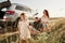 Enjoying nature. Family have picnic at countryside near silver automobile at sunset