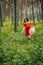 Enjoying the nature, wellness, wellbeing, healthy lifestyle, slow living. Young brunette girl in red dress and straw hat